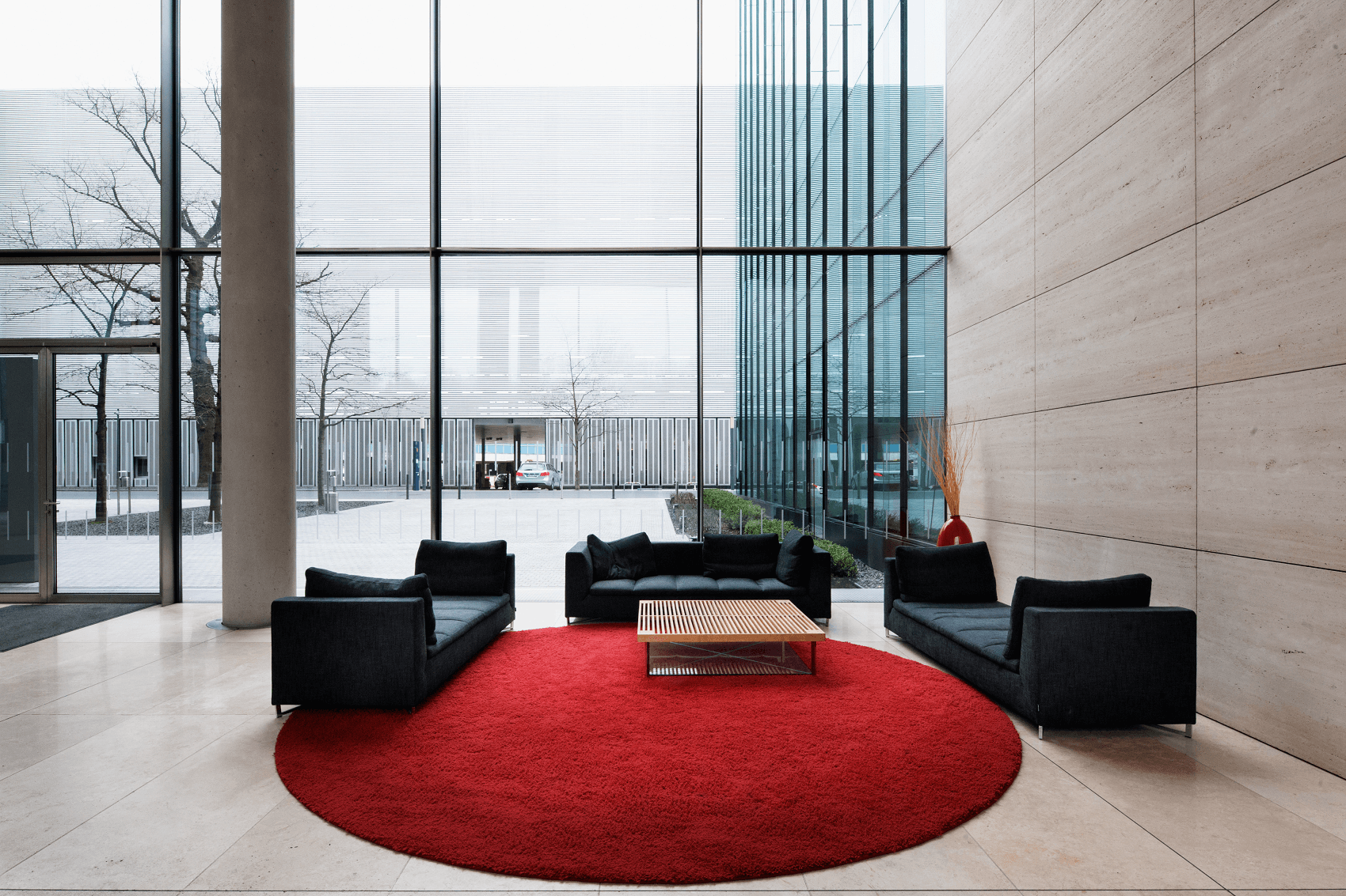 repräsentativer Eingangsbereich mit schwarzen Möbeln auf rotem runden Teppich
