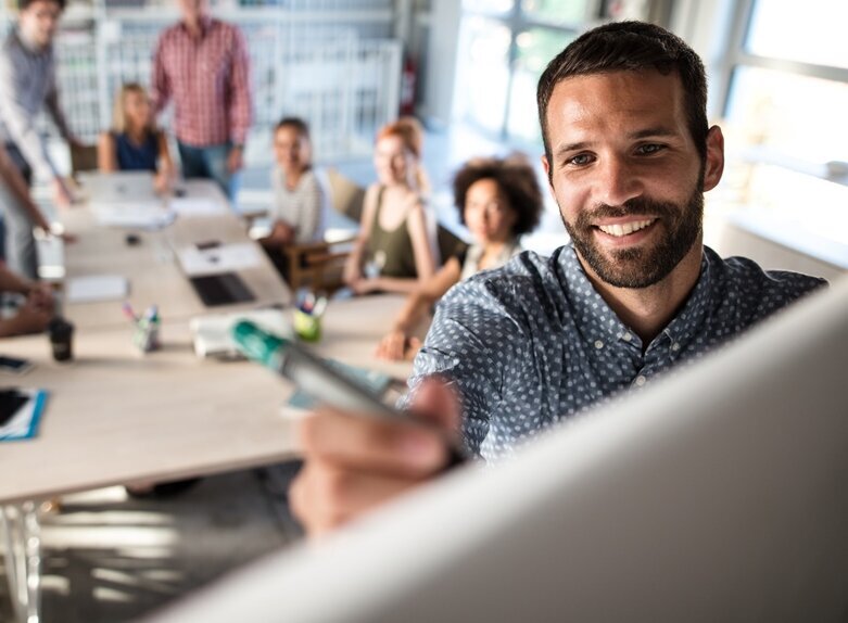 Junger Mann im Meeting schreibt an Whiteboard