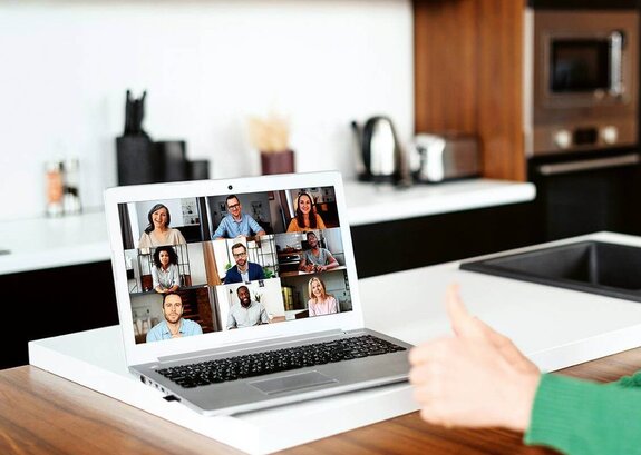 Eine Frau am Computer, die online mit anderen zusammen arbeitet