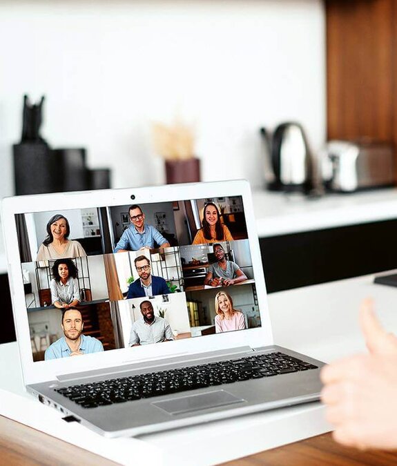 Eine Frau am Computer, die online mit anderen zusammen arbeitet
