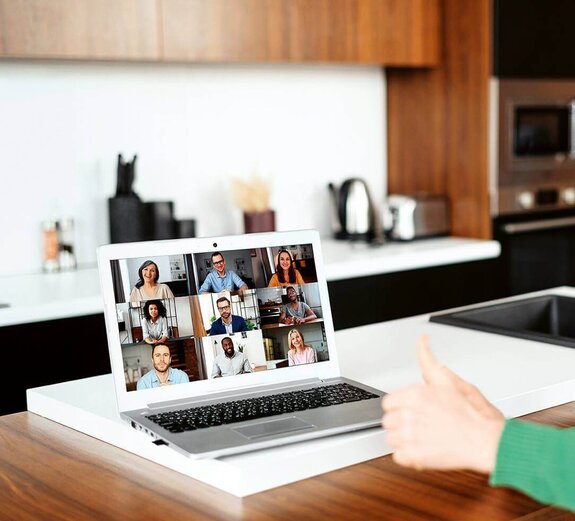 Eine Frau am Computer, die online mit anderen zusammen arbeitet