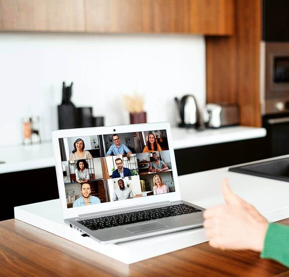 Eine Frau am Computer, die online mit anderen zusammen arbeitet