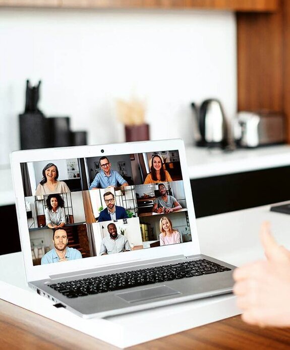 Eine Frau am Computer, die online mit anderen zusammen arbeitet