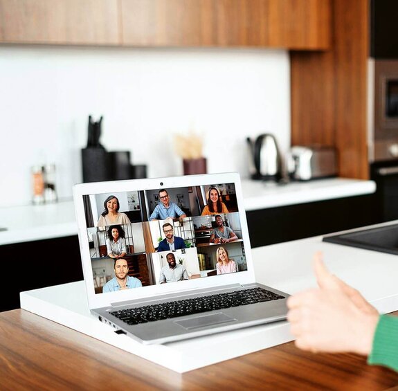 Eine Frau am Computer, die online mit anderen zusammen arbeitet