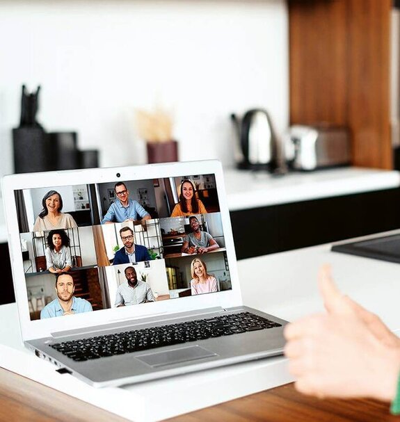 Eine Frau am Computer, die online mit anderen zusammen arbeitet