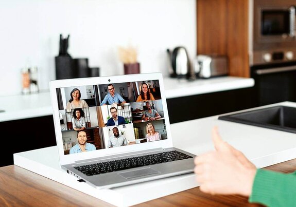 Eine Frau am Computer, die online mit anderen zusammen arbeitet