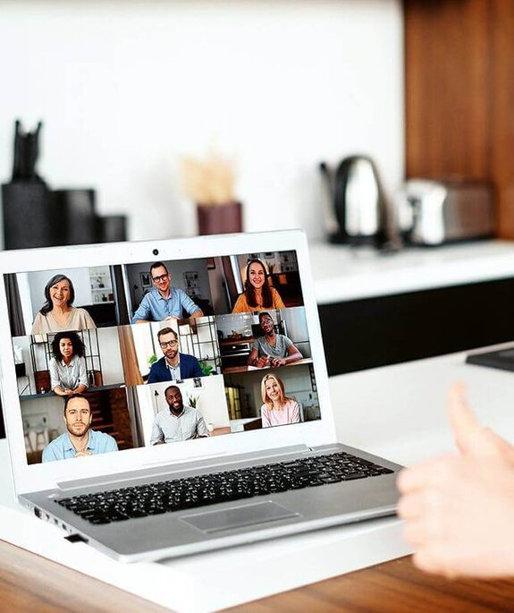 Eine Frau am Computer, die online mit anderen zusammen arbeitet