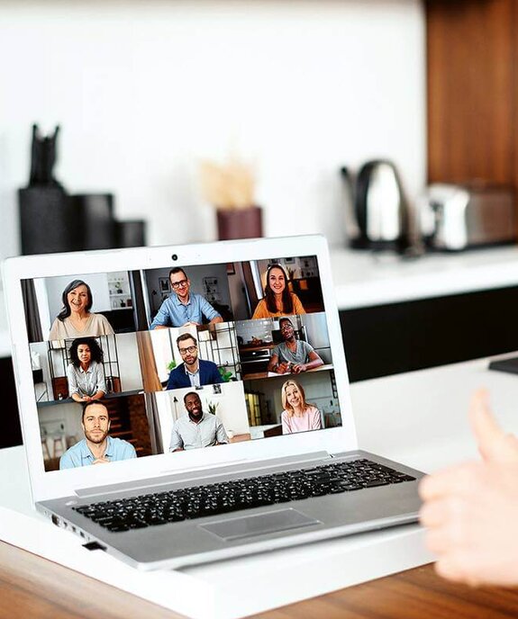 Eine Frau am Computer, die online mit anderen zusammen arbeitet