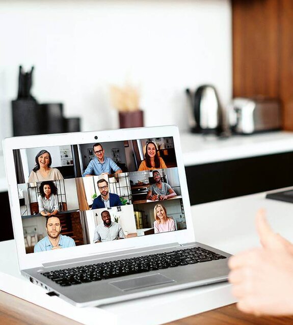 Eine Frau am Computer, die online mit anderen zusammen arbeitet