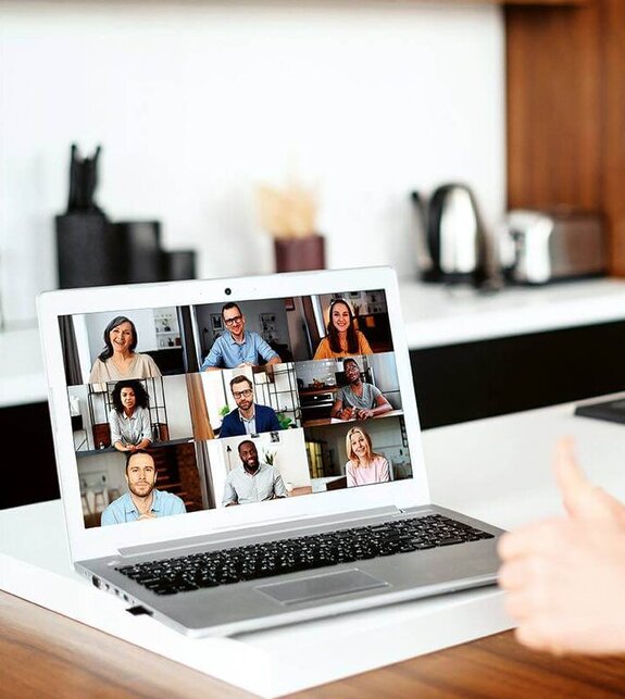 Eine Frau am Computer, die online mit anderen zusammen arbeitet