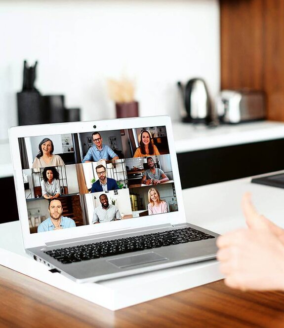 Eine Frau am Computer, die online mit anderen zusammen arbeitet