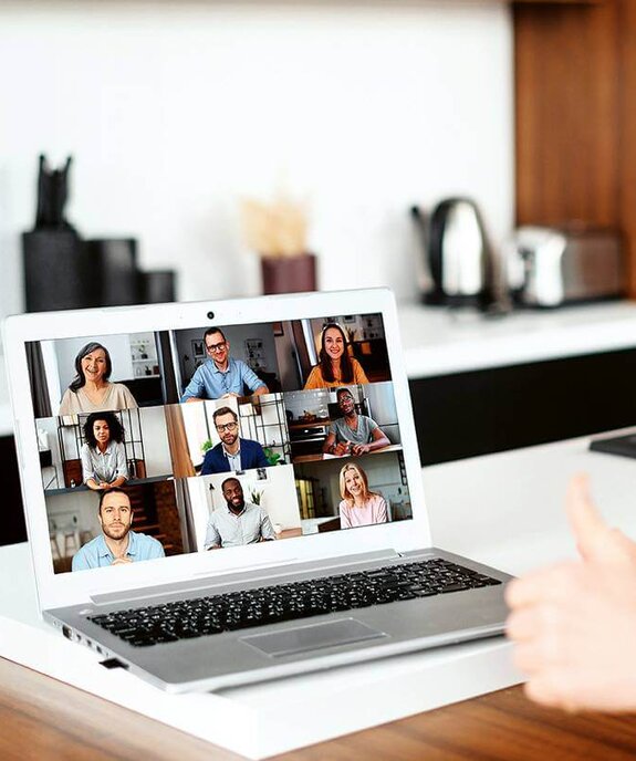 Eine Frau am Computer, die online mit anderen zusammen arbeitet
