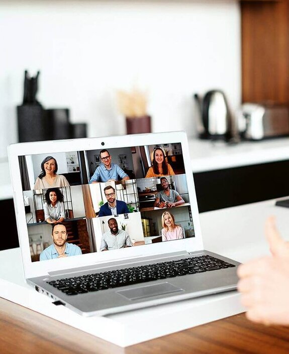 Eine Frau am Computer, die online mit anderen zusammen arbeitet