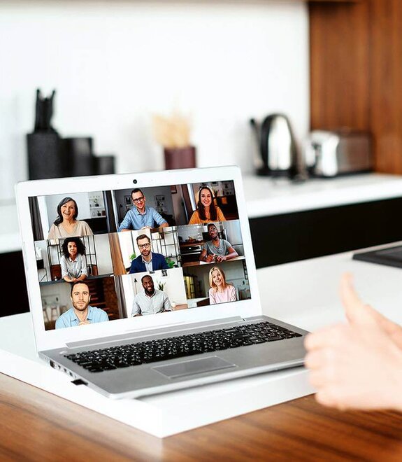 Eine Frau am Computer, die online mit anderen zusammen arbeitet