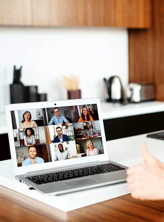 Eine Frau am Computer, die online mit anderen zusammen arbeitet
