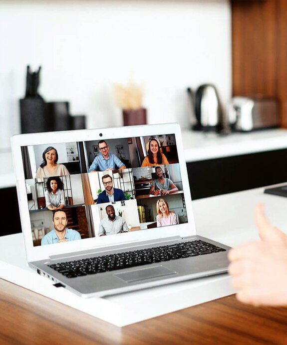 Eine Frau am Computer, die online mit anderen zusammen arbeitet
