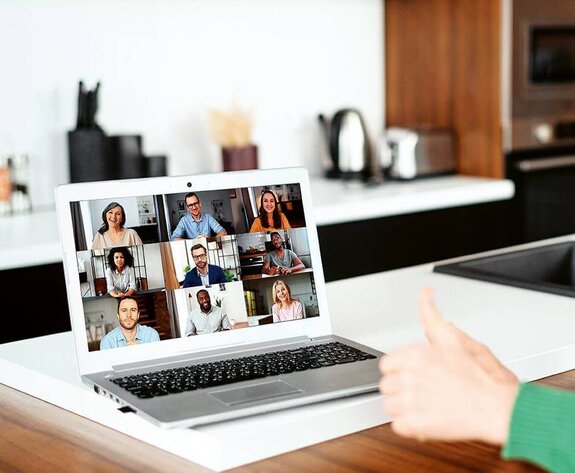 Eine Frau am Computer, die online mit anderen zusammen arbeitet