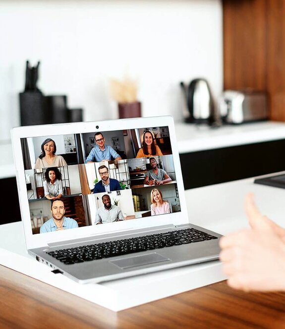 Eine Frau am Computer, die online mit anderen zusammen arbeitet