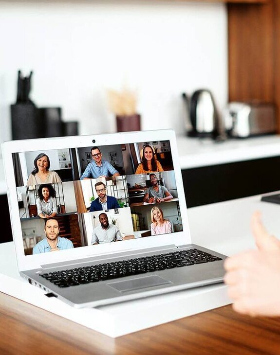 Eine Frau am Computer, die online mit anderen zusammen arbeitet