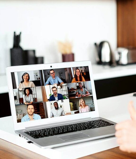 Eine Frau am Computer, die online mit anderen zusammen arbeitet