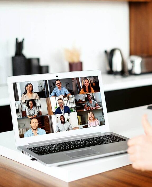 Eine Frau am Computer, die online mit anderen zusammen arbeitet