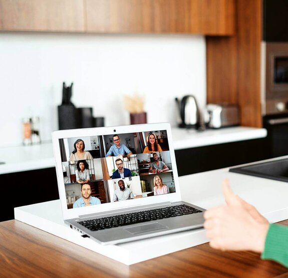 Eine Frau am Computer, die online mit anderen zusammen arbeitet