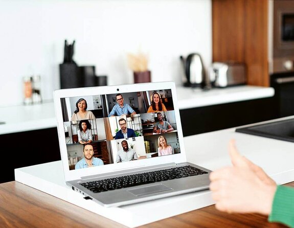 Eine Frau am Computer, die online mit anderen zusammen arbeitet