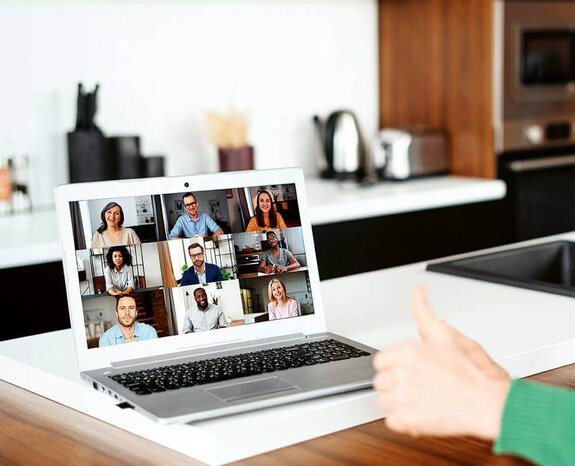 Eine Frau am Computer, die online mit anderen zusammen arbeitet