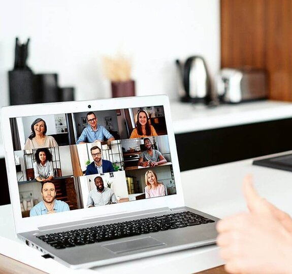 Eine Frau am Computer, die online mit anderen zusammen arbeitet