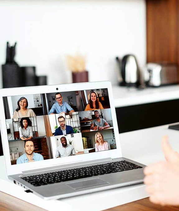 Eine Frau am Computer, die online mit anderen zusammen arbeitet