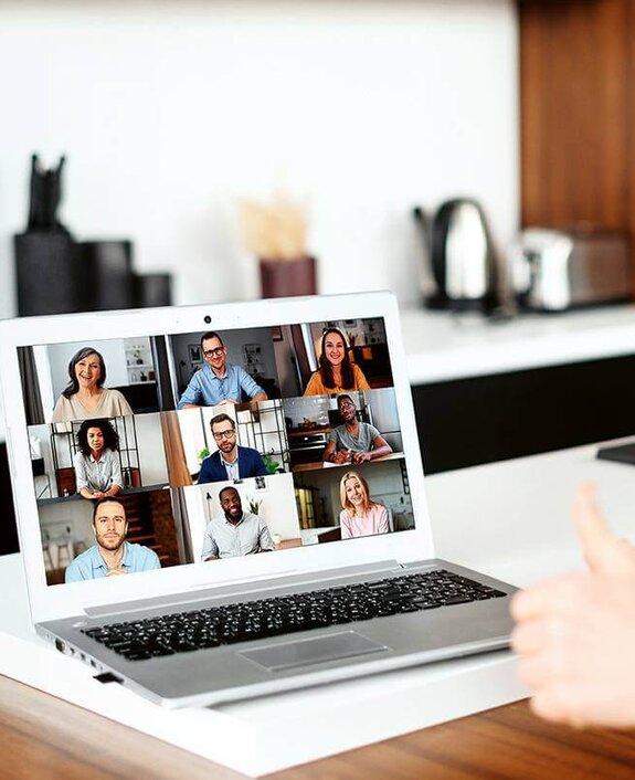 Eine Frau am Computer, die online mit anderen zusammen arbeitet