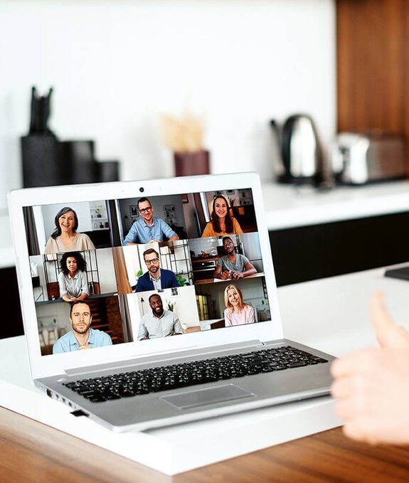 Eine Frau am Computer, die online mit anderen zusammen arbeitet