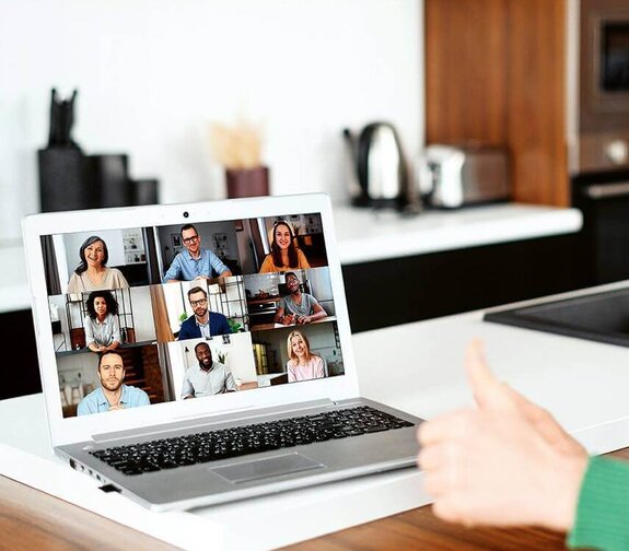 Eine Frau am Computer, die online mit anderen zusammen arbeitet