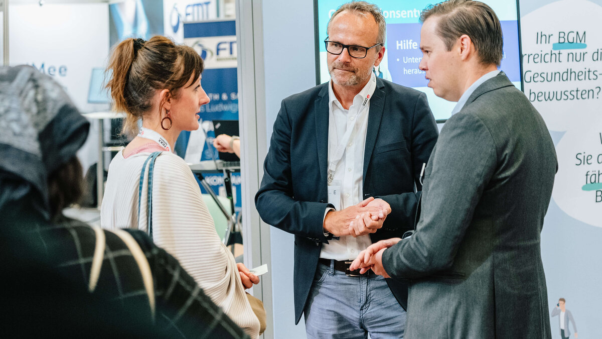 Nils Schilling (imh) und Marcell von Grunder (PREVENT) im Gespräch mit Interessierten am Messestand der ias-Gruppe
