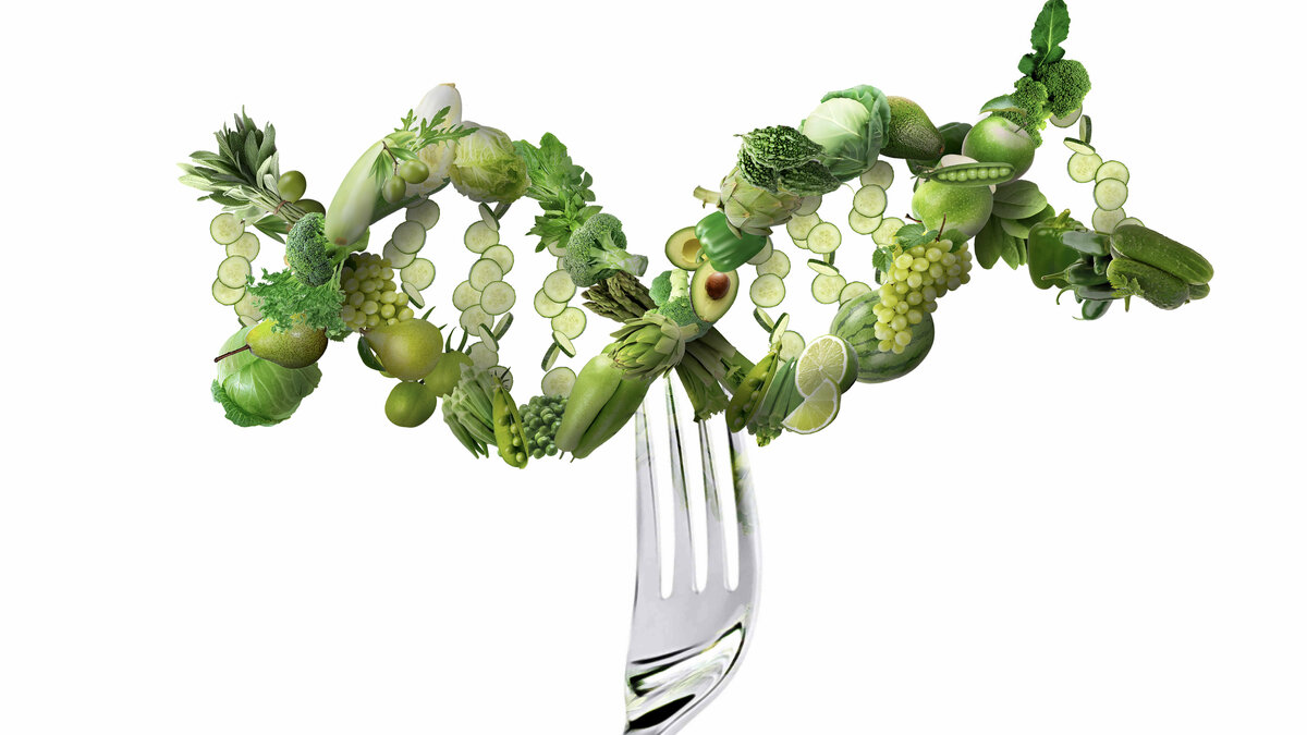 Das Bild zeigt eine Gabel welche eine grüne Doppelhelix aufspießt. Die Doppelhelix besteht aus  grünem Obst und Gemüse.