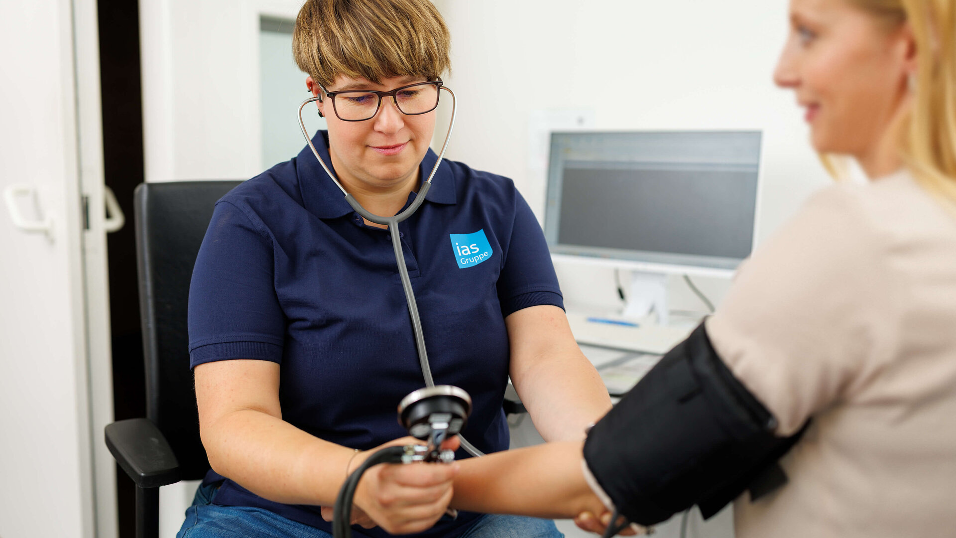 Arbeitsmedizinische Assistenz Jennifer Smarz misst Blutdruck bei einer arbeitsmedizinischen Untersuchung