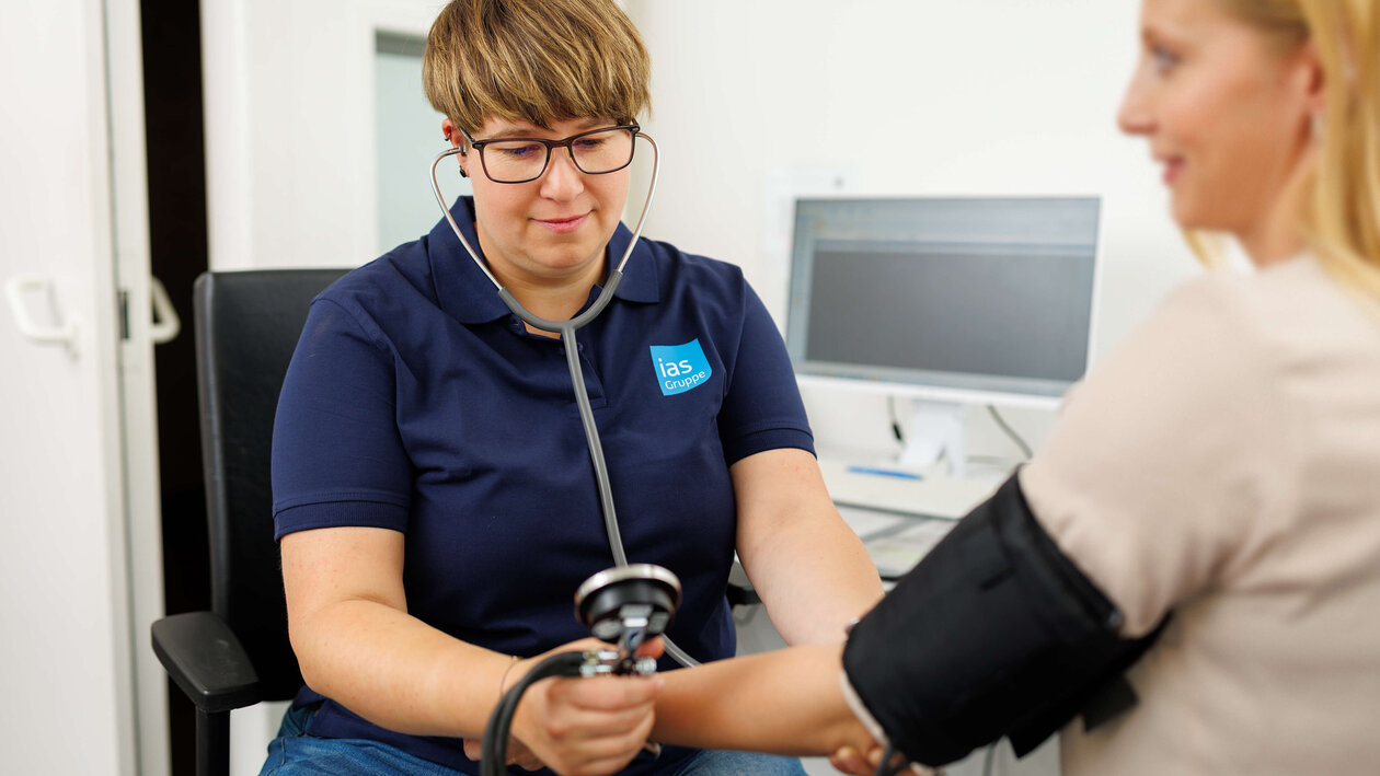Arbeitsmedizinische Assistenz Jennifer Smarz misst Blutdruck bei einer arbeitsmedizinischen Untersuchung