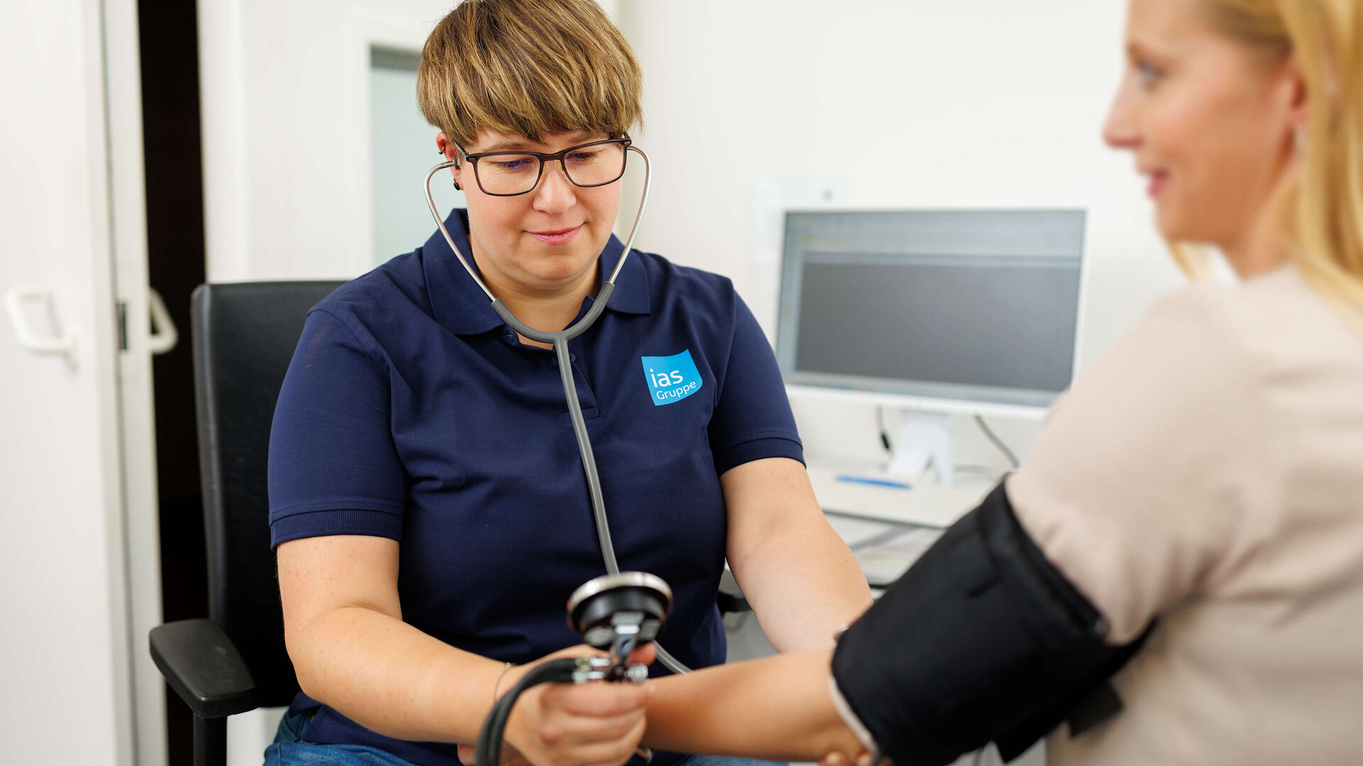 Arbeitsmedizinische Assistenz Jennifer Smarz misst Blutdruck bei einer arbeitsmedizinischen Untersuchung