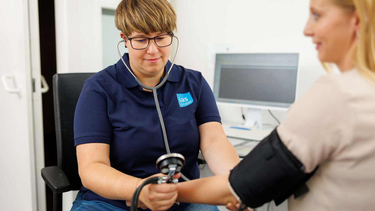 Arbeitsmedizinische Assistenz Jennifer Smarz misst Blutdruck bei einer arbeitsmedizinischen Untersuchung