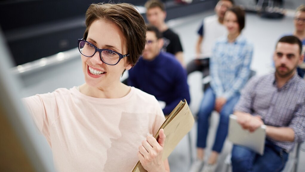 Seminare für Unternehmen junge Frau mit Brille schreibt am Flipchart