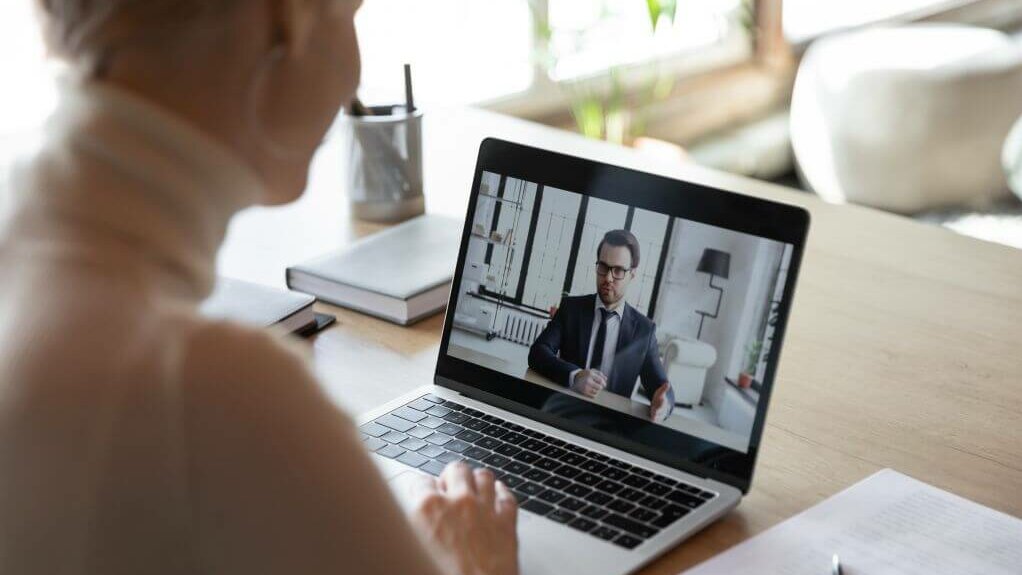 Business-Frau vorm Laptop im Online-Meeting
