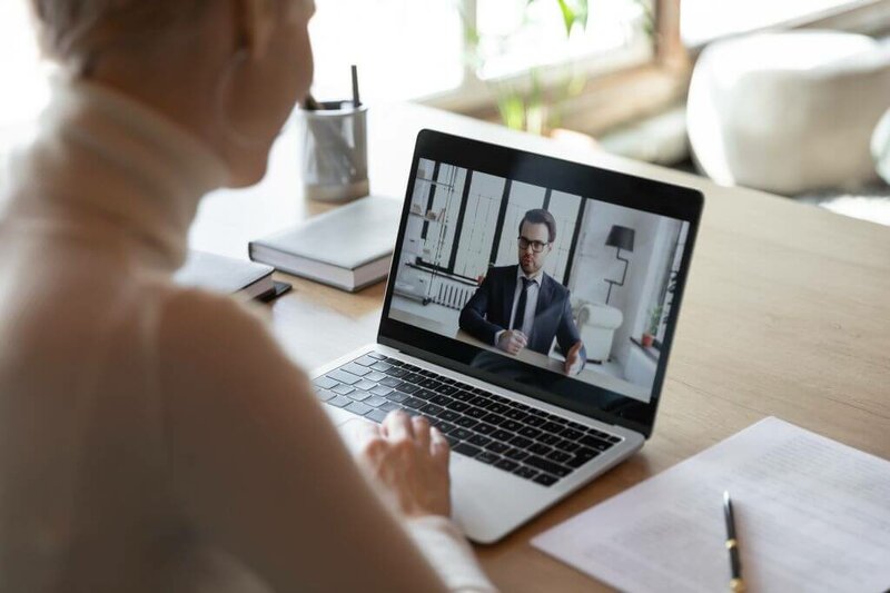 Business-Frau vorm Laptop im Online-Meeting