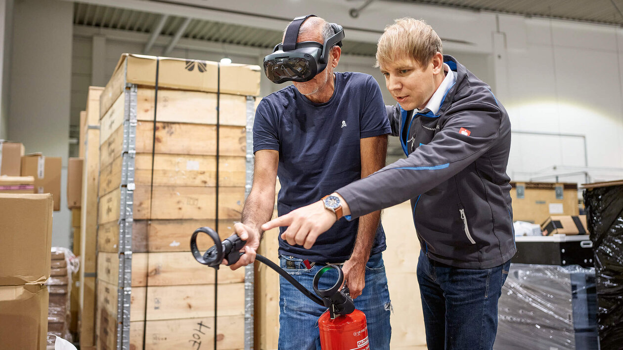 Brandschutzausbildung mit Virtuell Reality, zwei Personen üben mit einem Feuerlöscher einen simulierten Brand zu löschen