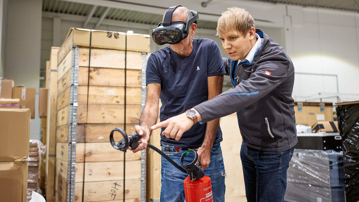 Brandschutzausbildung mit Virtuell Reality, zwei Personen üben mit einem Feuerlöscher einen simulierten Brand zu löschen