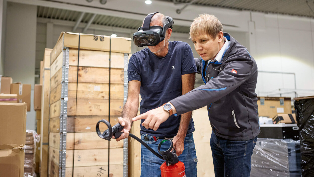 Brandschutzausbildung mit Virtuell Reality, zwei Personen üben mit einem Feuerlöscher einen simulierten Brand zu löschen