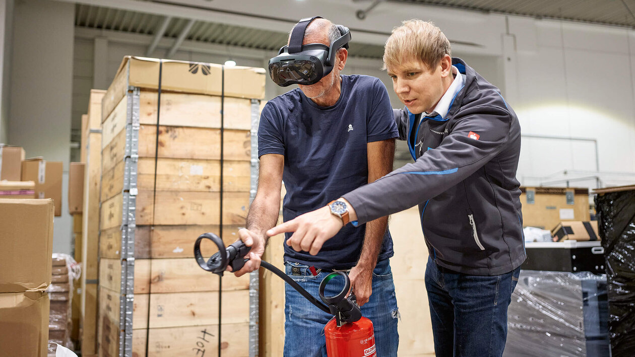 Brandschutzausbildung mit Virtuell Reality, zwei Personen üben mit einem Feuerlöscher einen simulierten Brand zu löschen