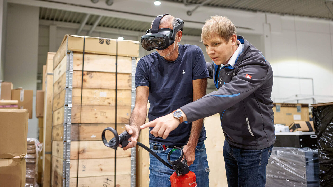 Brandschutzausbildung mit Virtuell Reality, zwei Personen üben mit einem Feuerlöscher einen simulierten Brand zu löschen