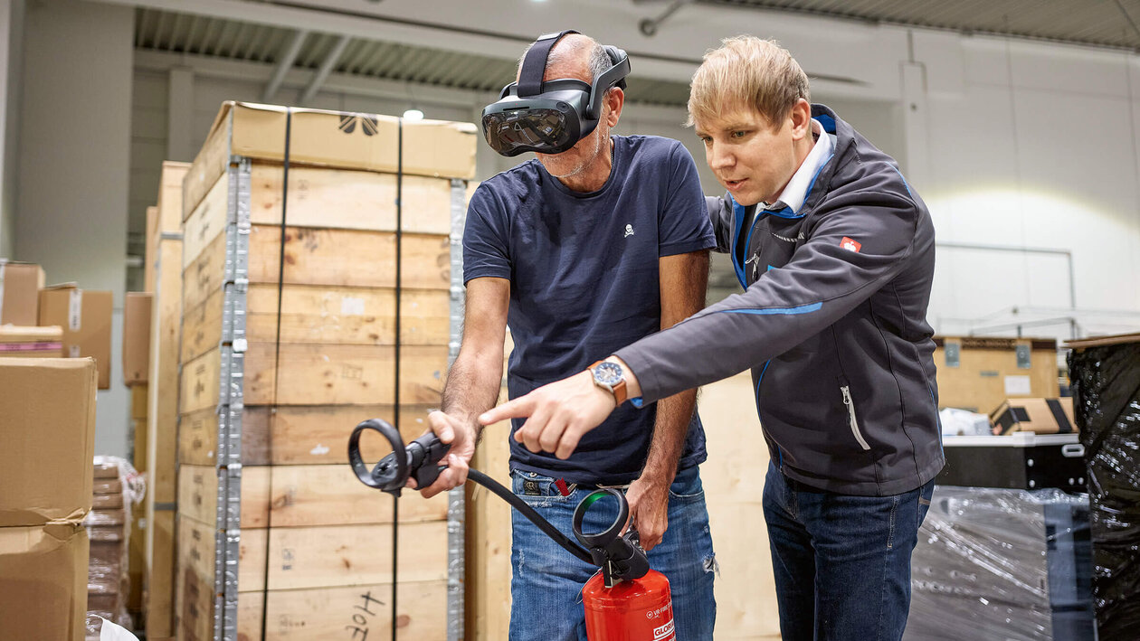 Brandschutzausbildung mit Virtuell Reality, zwei Personen üben mit einem Feuerlöscher einen simulierten Brand zu löschen