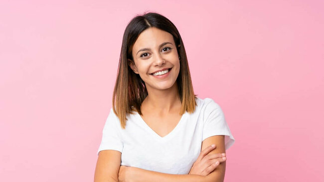 lächelnde junge Frau, rosa Hintergrund