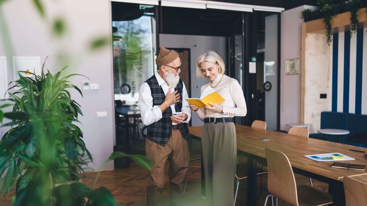 Ein modernes älteres Paar steht in einem individuell eingerichtetem Wohnumfeld